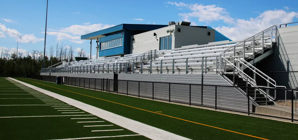 Outdoor grandstands with press box along athletic field.