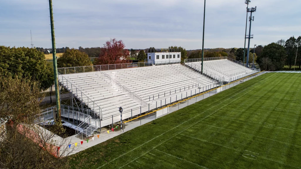 Outdoor grandstands with press box along athletic field.