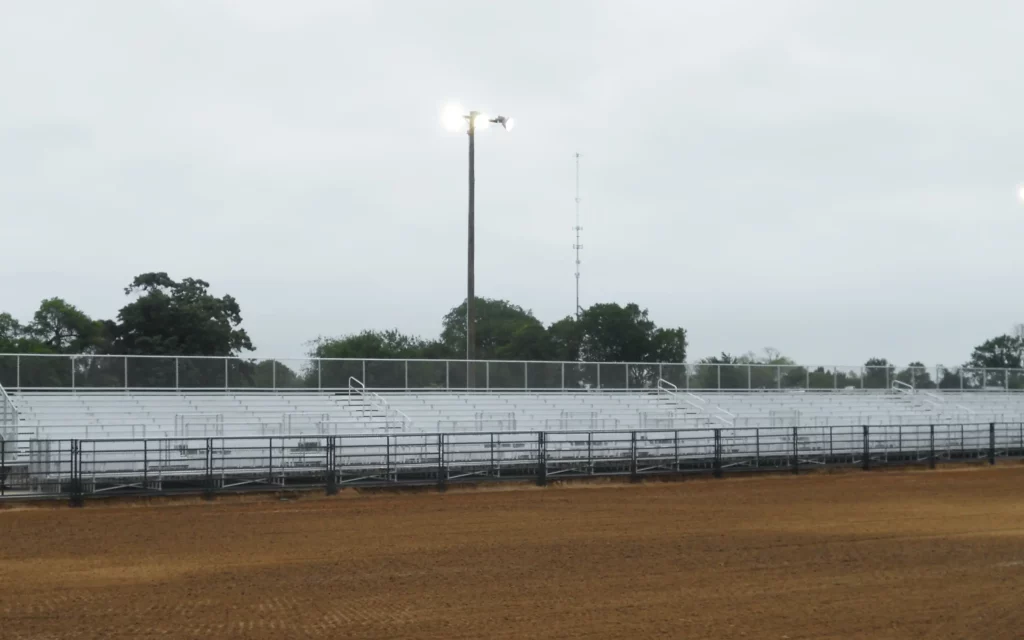 Outdoor elevated bleachers along dirt arena.