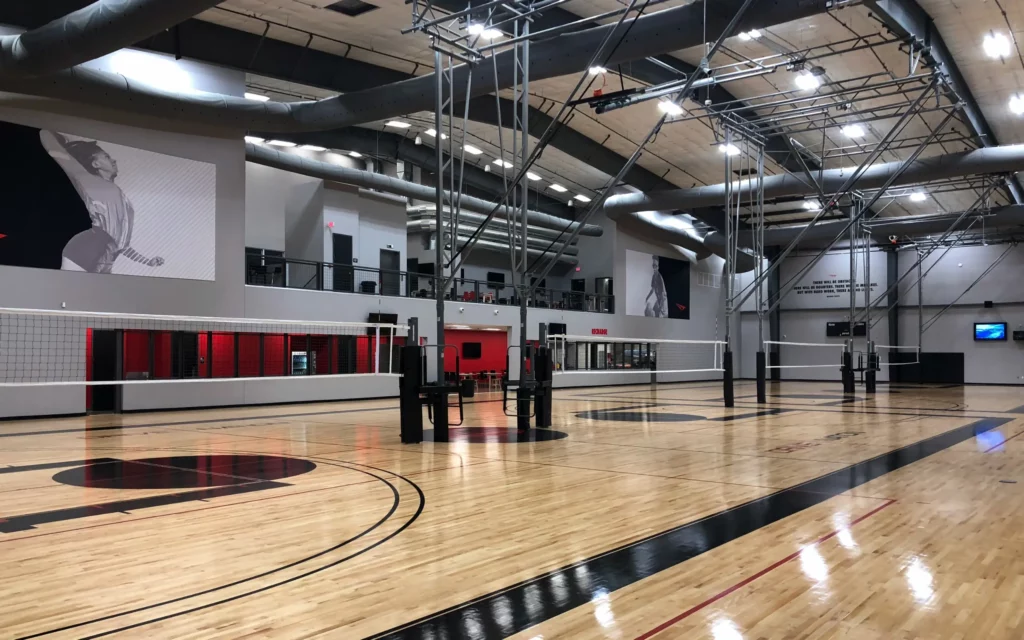 Four indoor volleyball systems and nets installed in gym.